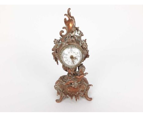 19th century French brass mantel clock, decorated in the rococo style with a cherub, scrollwork motifs and flowers, with enam