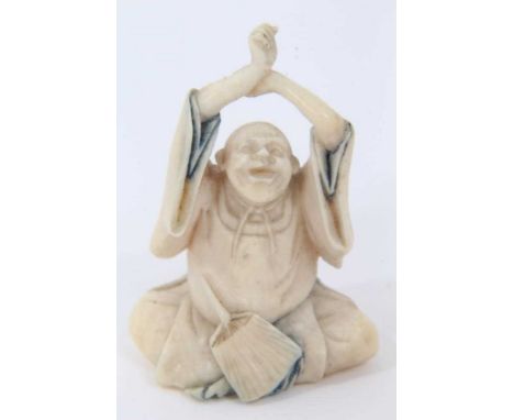 Fine Japanese carved ivory netsuke, carved as a seated holy man, polychrome detail, 4cm high