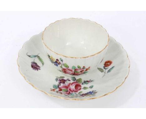 Worcester fluted tea bowl and saucer, circa 1772, polychrome painted with flowers, with gilt rims, the saucer measuring 13.5c