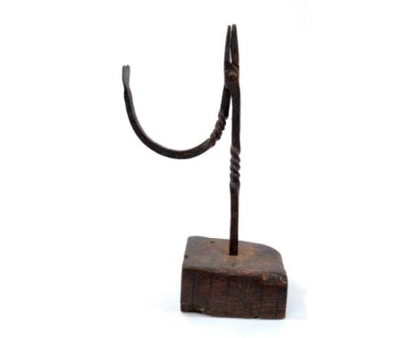 18th century wrought iron nip rush light holder, the arm with heart form terminal, raised on square oak plinth, 30cm high