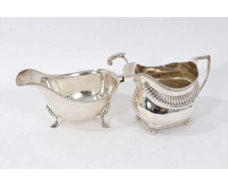 George III silver cream jug of compressed baluster form, with fluted decoration and gadrooned border, on four ball feet (lond