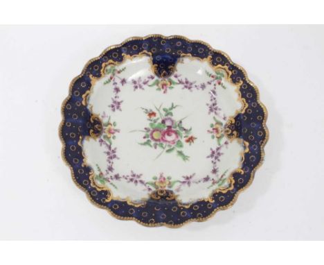 Worcester plate, circa 1772, polychrome painted with flowers, with 'Sèvres' style blue and gilt border, crescent mark to base