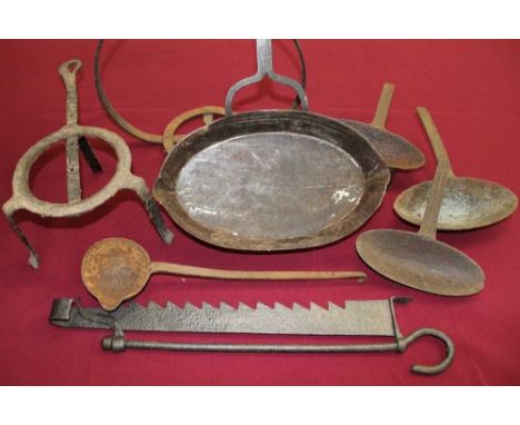 Collection of antique wrought iron fireside equipment, including two chimney cranes, receptacles, antique waffle iron, trivet