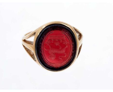 Victorian gold signet ring, the oval garnet/red coloured glass bezel with intaglio engraved family crest depicting a lion abo