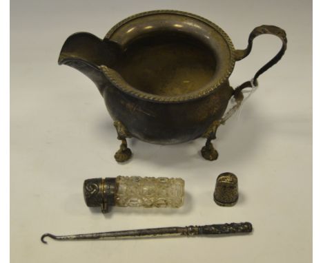 A silver cream jug, Sheffield 1949; a silver topped smelling salts jar, Birmingham 1902 ; a silver thimble Birmingham 1889; a
