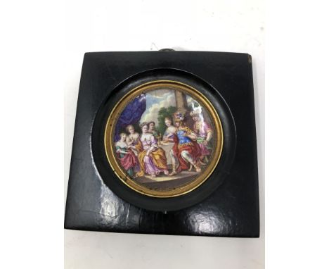 An early 19th Century framed enamel dish depicting an 18th Century classical scene, possibly Royalty, with figures seated at 