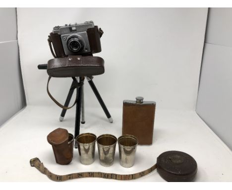 A box containing a pair of binoculars and binocular cases, cameras, hip flask and shot glasses and an L.M.S. tape, etc.