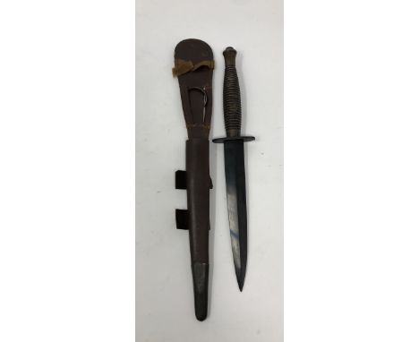 A WWII third pattern Commando knife in its original leather scabbard with metal mounts. The blade has no knocks and retains a