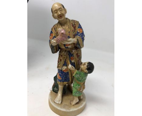 A Japanese ceramic figure of a man and boy.