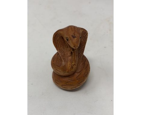 A Japanese carved wood netsuke in the form of a coiled cobra.
