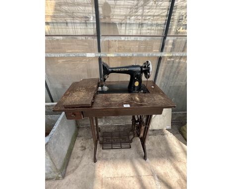 A VINTAGE SINGER SEWING MACHINE WITH TREADLE BASE