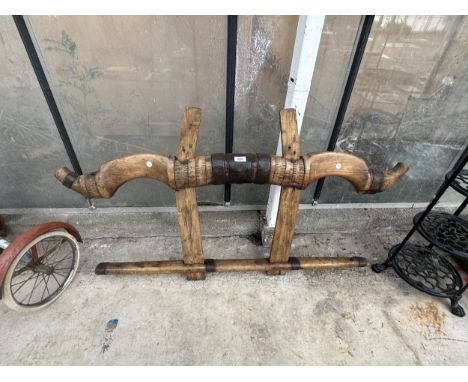 A VINTAGE WOODEN AND METAL BANDED OX YOKE