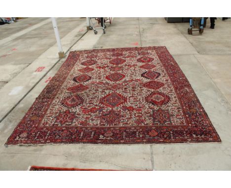 A LARGE VINTAGE RED PATTERNED FRINGED RUG