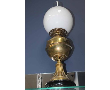 BRASS OIL LAMP
decorated with floral motifs and over an ebonised circular base, with dome, 61cm high