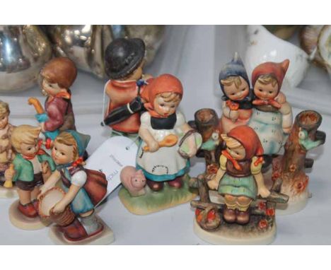GROUP OF HUMMEL FIGURINES
including a boy and girls resting on a branch, 13cm high, with seven others (8)
