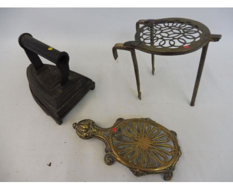 A heavy flat iron marked Silvesters Patent and a trivet marked R M M. plus two brass trivets.