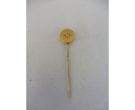 A high carat gold mounted diamond inset stick pin. 