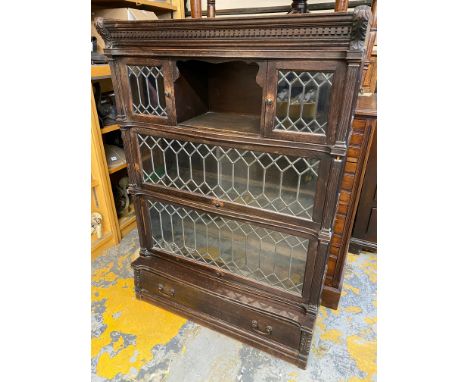 An Edwardian oak globe wernicke style four tier stacking bookcase of three glazed sections abover a drawer, the glazing with 