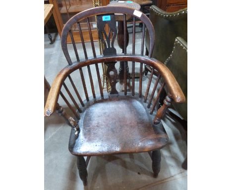 An early 19th century oak Windsor chair, the back with pierced shaped splat, on ring turned legs with crinoline stretcher.