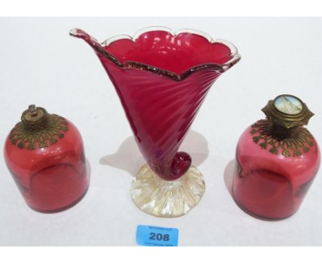 A pair of Victorian cranberry glass cologne bottles (one lacking lid) and a ruby glass cornucopia vase