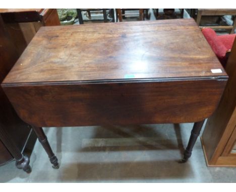 A George IV mahogany Pembroke table with one real and one faux frieze drawers on ring turned tapered legs with brass caps and