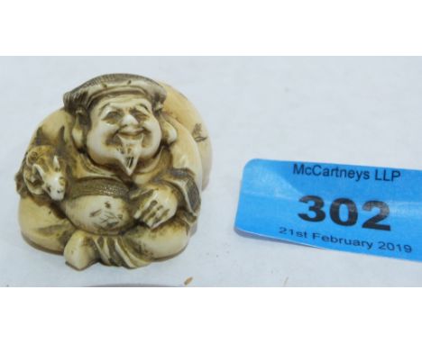 A Japanese carved ivory netsuke of a fat man with fawn and sack. Meiji. Signed