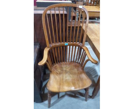 An ash and elm Windsor elbow chair on ring turned splayed legs