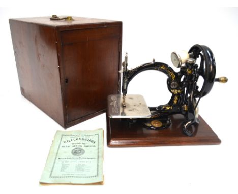 A Willcox & Gibbs 1883 patent sewing machine, with case and original direction manual