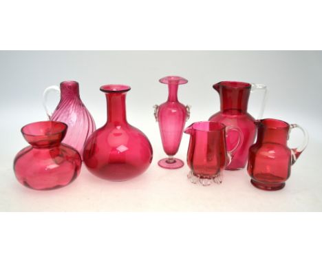 Victorian cranberry glass comprising a decanter and stopper, pot and cover, sugar bowl and matching milk jug and three furthe