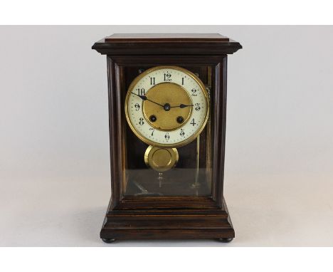 A wooden and glass cased mantel clock with white and gilt circular dial and Arabic numerals, with eight-day striking movement