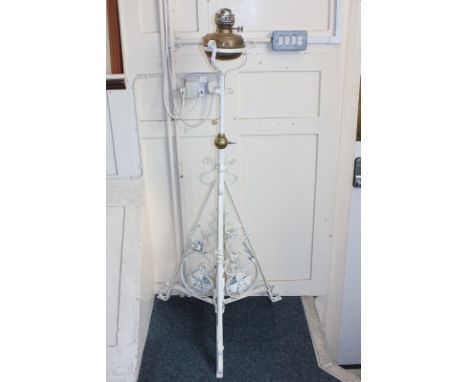 A painted wrought iron oil lamp standard with scroll and flower decoration and brass oil bowl