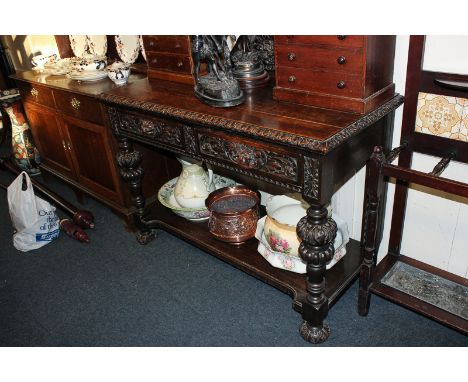 A Victorian oak side table with two drawers with lion mask handles on bulbous legs with open shelf base