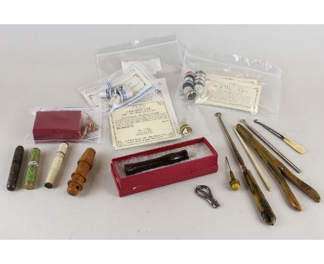 A small collection of needlework items including bodkin cases, button hooks and thimbles with certificates from The Thimble C