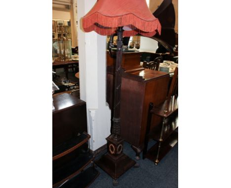 A mahogany lamp standard with tapered reeded column on square and sloping base