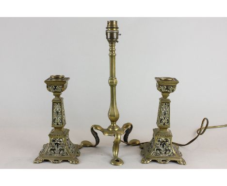 A pair of brass candlesticks, square baluster form with pierced scrolls, 19cm, and a brass table lamp stand on tripod feet