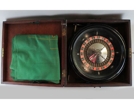 A roulette wheel, table cloth and croupier stick, in mahogany case with brass carry handles, 46cm