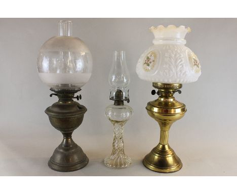 A brass base table oil lamp with glass shade, another glass oil lamp and another with frosted and clear glass shade