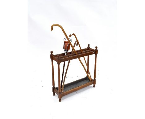 A late 19th century oak twelve division stick stand with zinc drip tray, 71 cm x 22 cm x 71 cm h, to/with assorted sticks