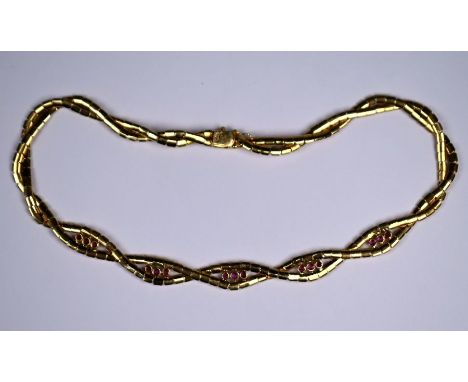 A yellow metal and ruby plaited necklace, the bloomed rectangular links interlaced to form twists, the front five with a trio