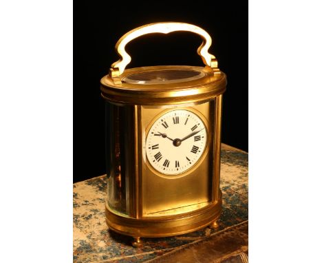A late 19th century French gilt brass oval carriage timepiece, 5cm enamel clock dial inscribed with Roman numerals, key-wound