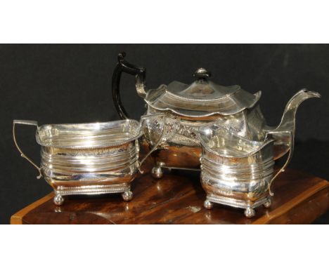 A  George III Irish silver three pierce boat shaped tea service, comprising teapot, milk jug and sugar basin, each bright-cut