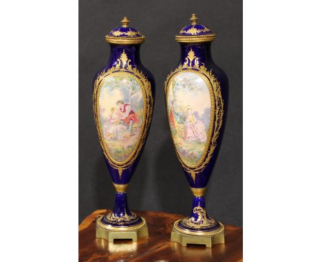 A pair of French gilt metal mounted porcelain slender ovoid vases, painted in the manner of Sèvres with a musical serenade an