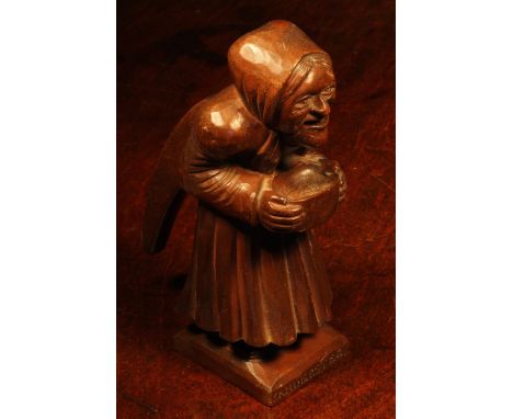 Nutcrackers - a Black Forest novelty table top lever-action nut cracker, carved as an elderly lady holding a bowl, 17.5cm hig