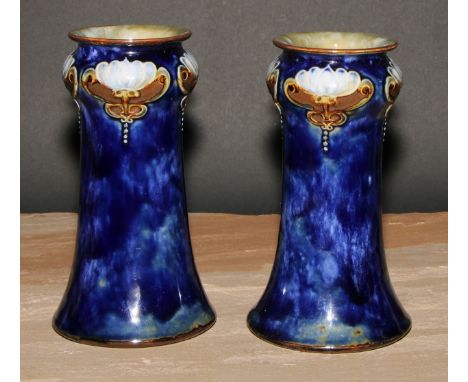 A pair of Art Nouveau Royal Doulton stoneware vases, by Maud Bowden, moulded with stylised flowers and glazed in tones of mot