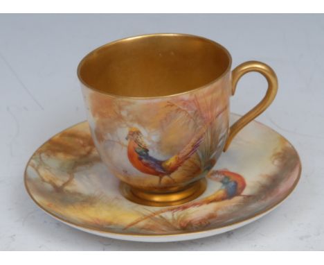 A Royal Worcester cabinet cup and saucer, painted by Walter Sedgley, signed, with golden pheasant, gilt interior, printed cro