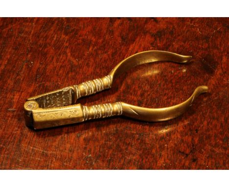 Nutcrackers - an early 18th century brass lever-action nut cracker, decorated with wrigglework, 11cm long, c.1720 