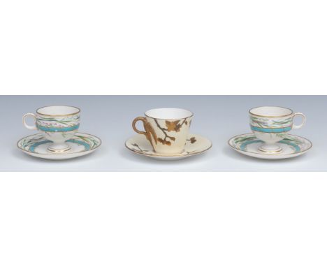 A pair of Royal Worcester pedestal teacups and saucers, painted with grasses over a raised gilt and turquoise band, impressed