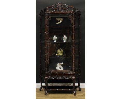 A Chinese hardwood porcelain vitrine or display cabinet, shaped pediment pierced and carved with fruiting vine, above a glaze