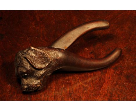 Nutcrackers - a Black Forest novelty lever-action nut cracker, carved as the head of a dog, glass eyes, 15cm long, c.1900 