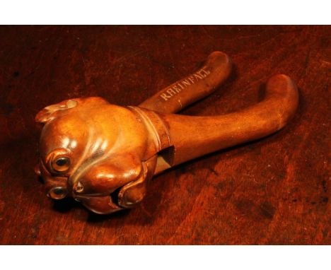 Nutcrackers - a Black Forest lever-action nut cracker, boldly carved as the head of a bulldog, glass eyes, the grip inscribed